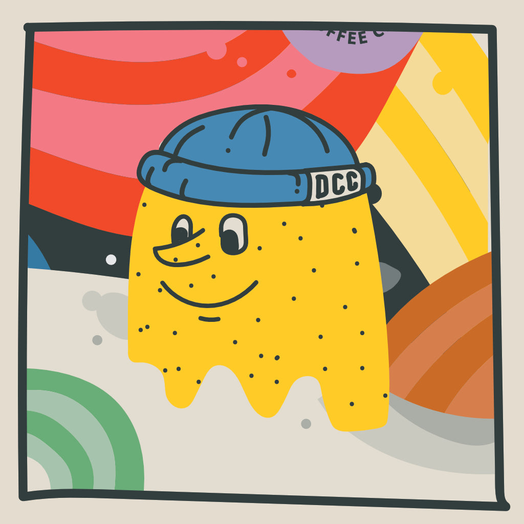 Rhys, the Decaf Coffee Club character who is yellow wearing a rolled blue beanie with DCC on it.
