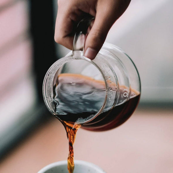A Hario V60 360ml Range Server filled with coffee being poured out.