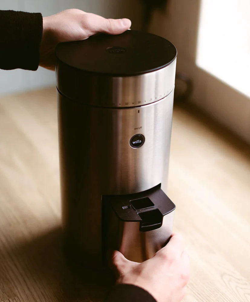 The Wilfa Uniform Coffee Grinder being emptied by a person