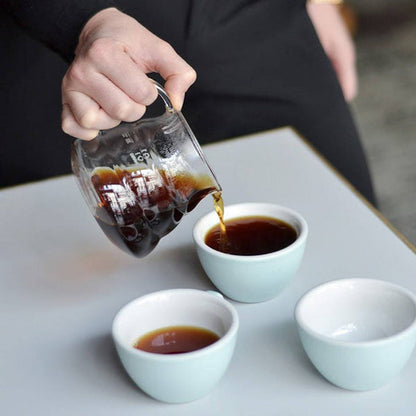 A Hario V60 360ml Range Server pouring coffee into three white mugs
